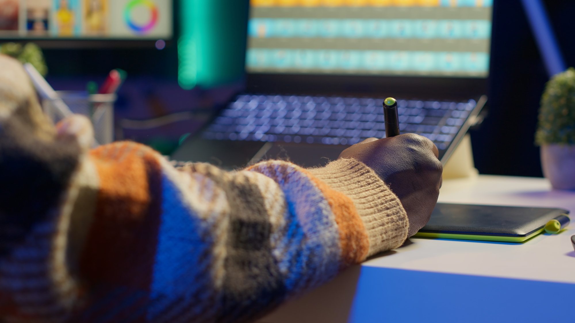 Male graphic artist using essential digital tools on dual monitors