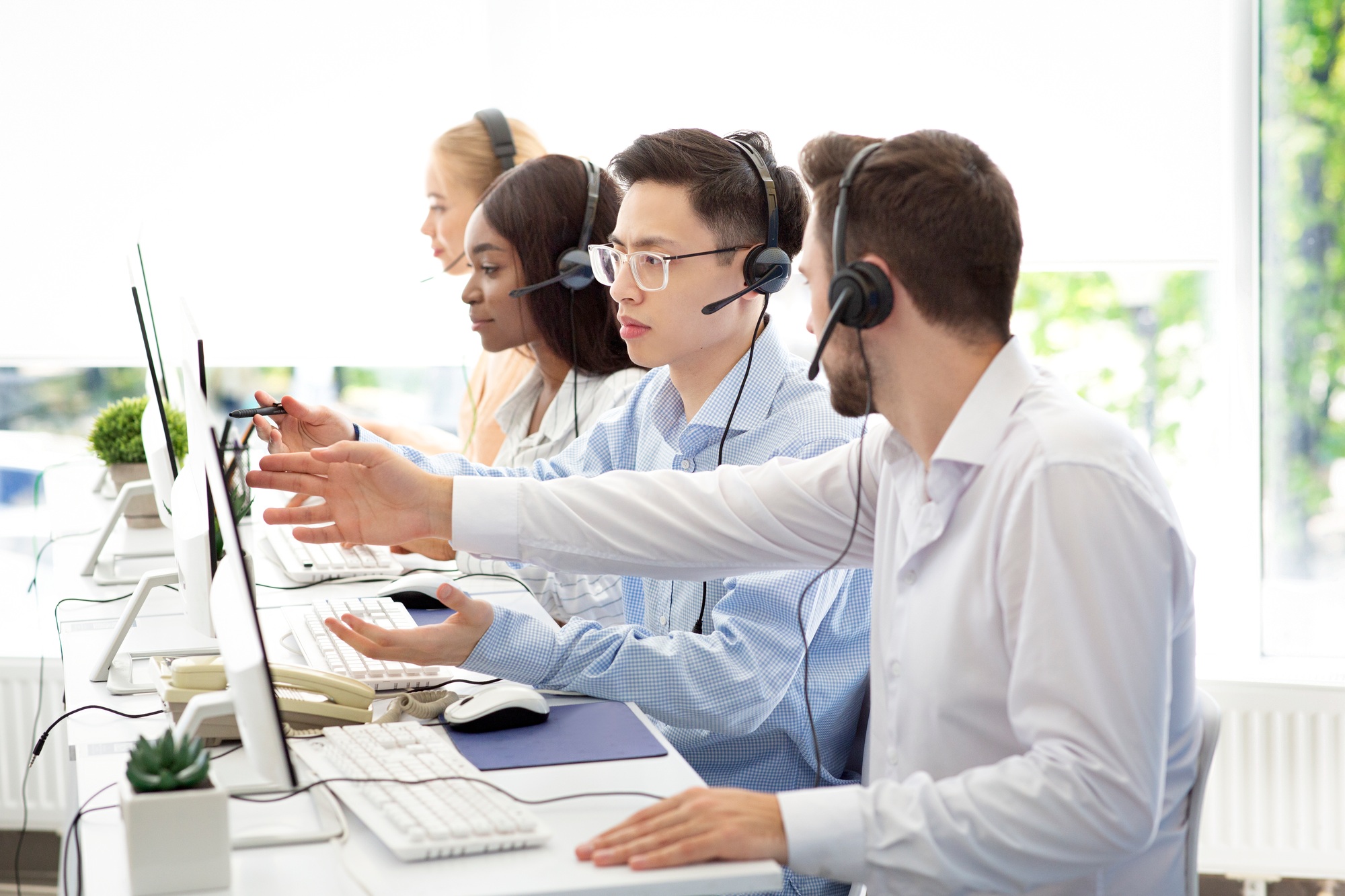 Customer support service concept. Helpline operator consulting his colleague at call centre